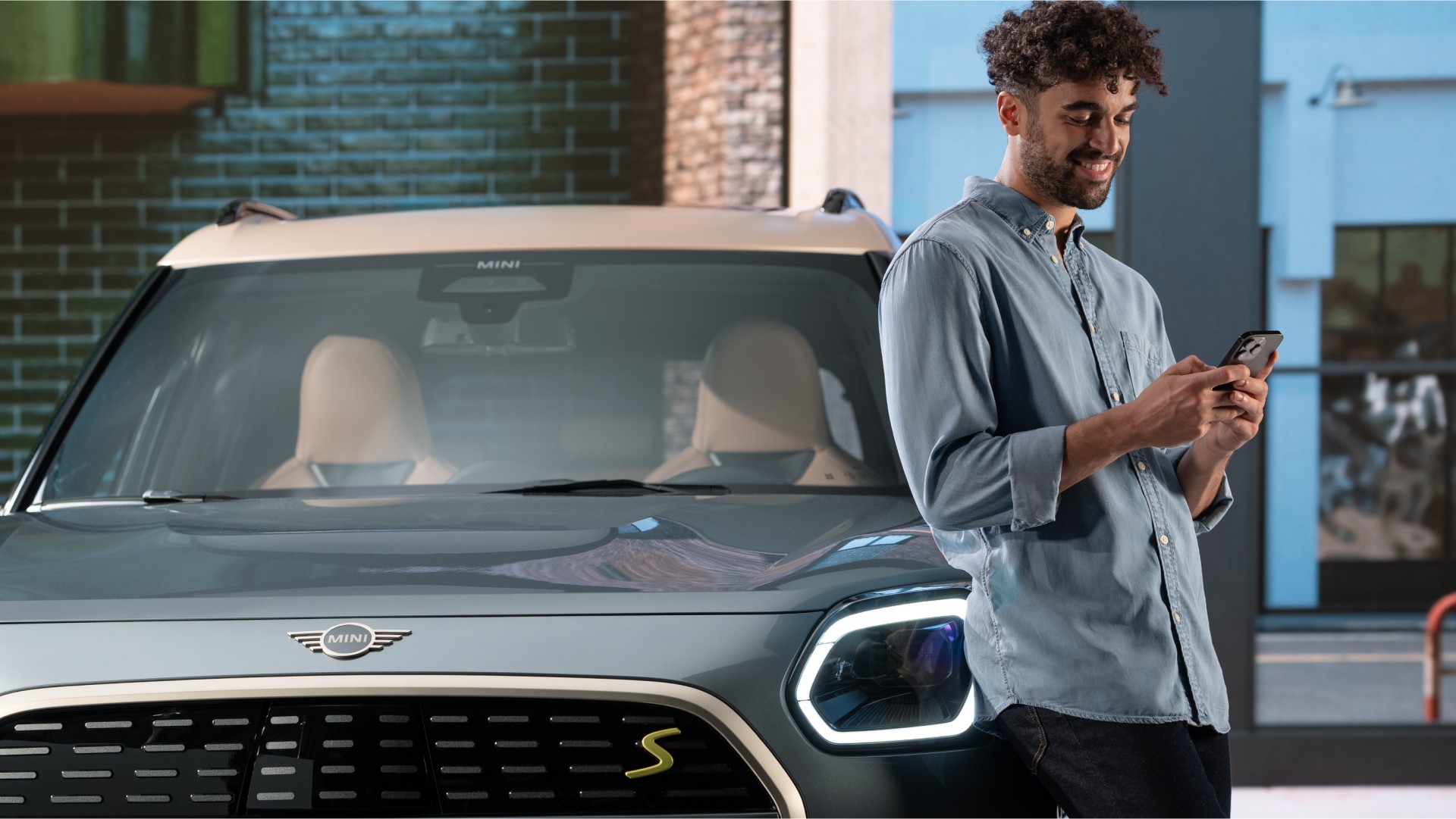 MINI vooraanzicht, detail, met man die tegen MINI leunt